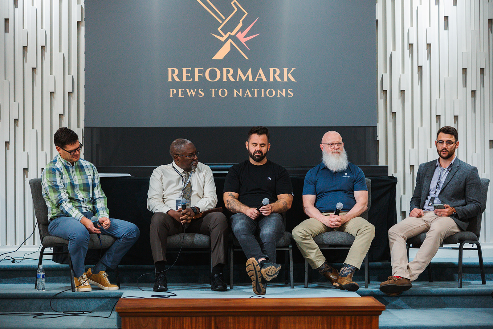 Panel of speakers on stage at the Pews to Nations conference